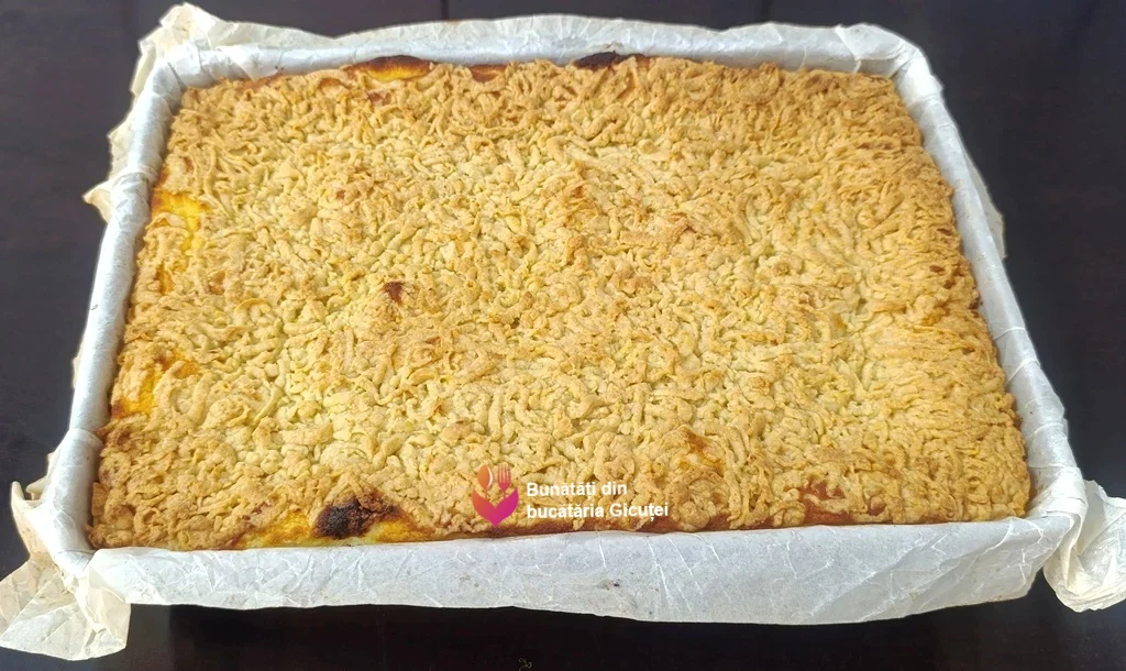 tava cu prajitura cu aluat ras si branza scoasa din cuptor
